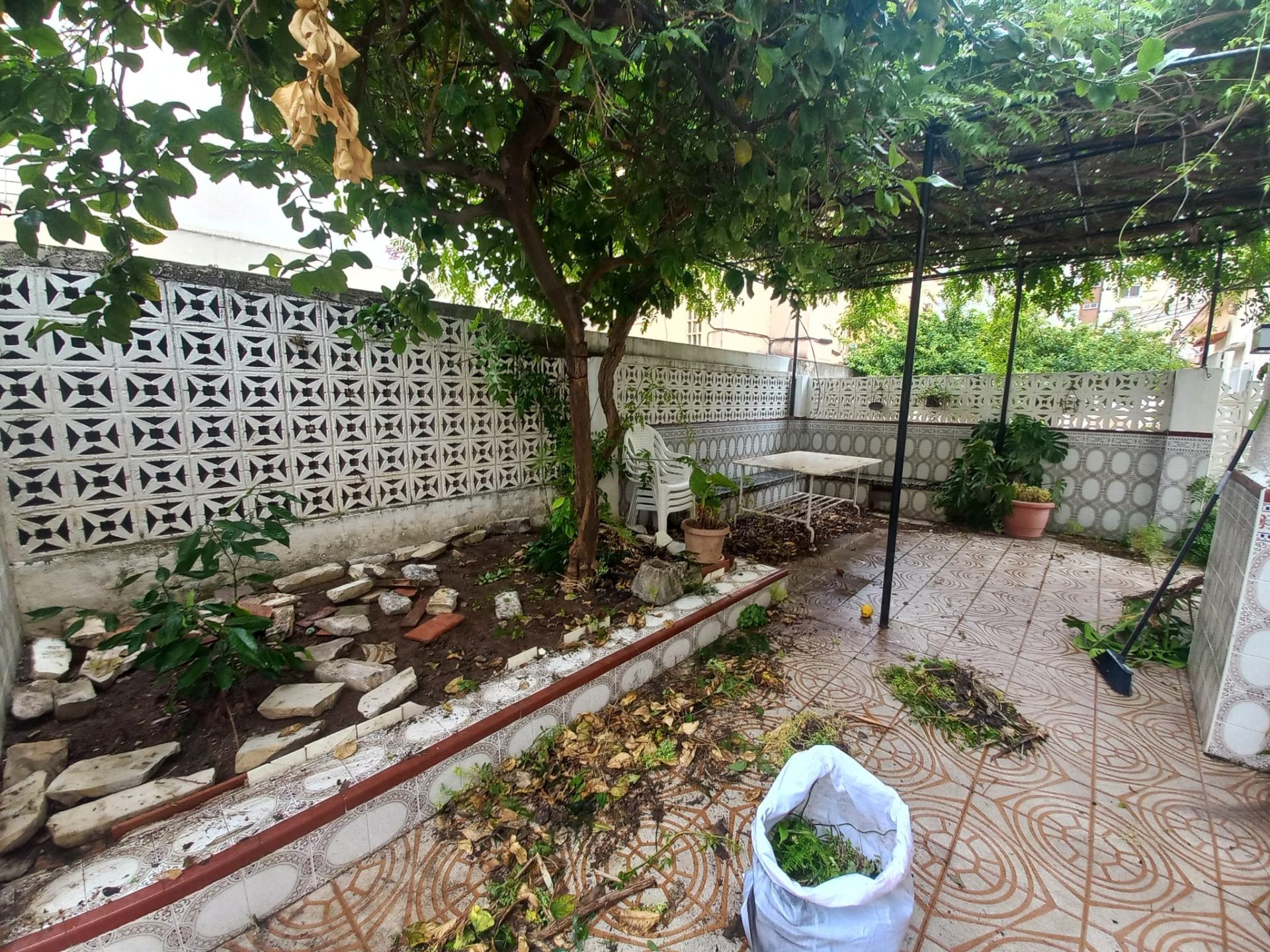 Jardín con escombros y hojarasca antes del vaciado